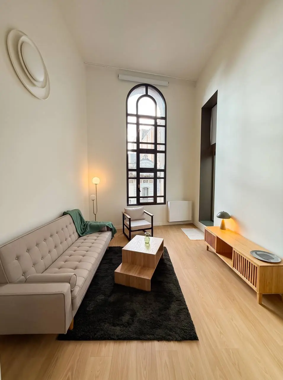 Duplex living room with an arched floor-to-ceiling window